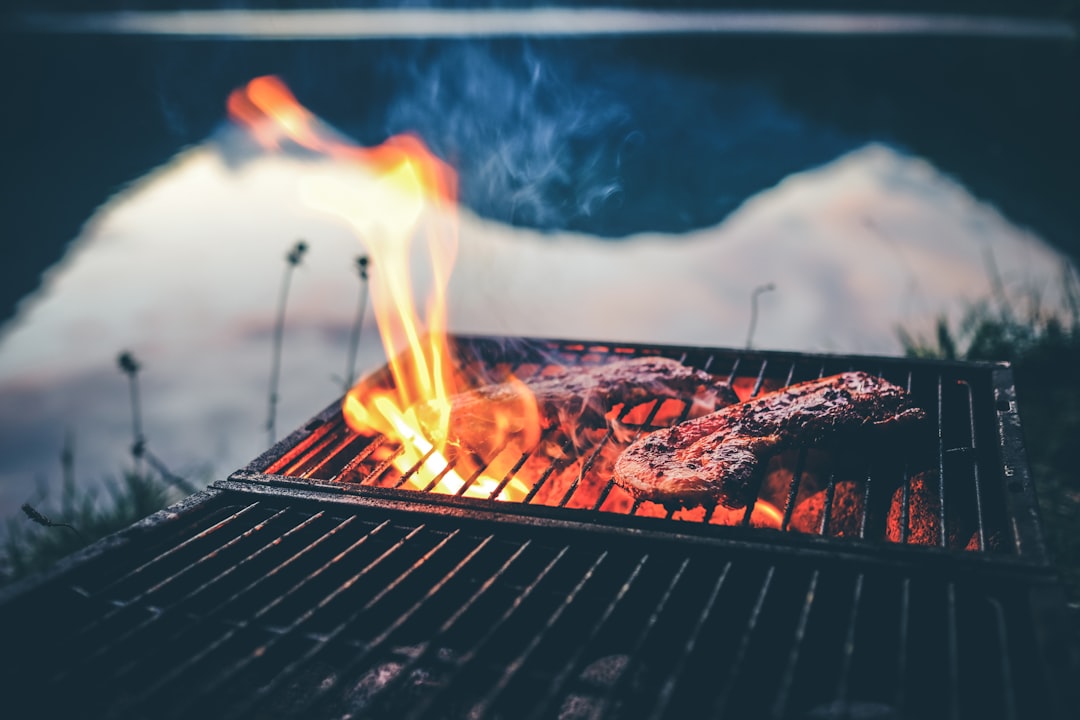 Verre de vin rouge à côté d'une viande grillée fumante
