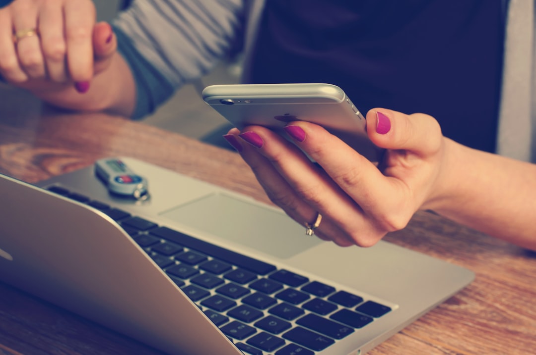 Mains tenant un téléphone avec un formulaire de contact visible à l'écran